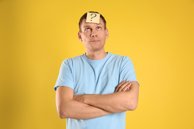 Photo of Emotional man with question mark on yellow  background