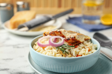 Photo of Delicious chicken risotto served in bowl on table