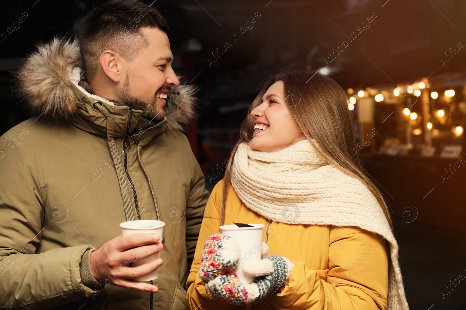 Photo of Happy couple with mulled wine at winter fair