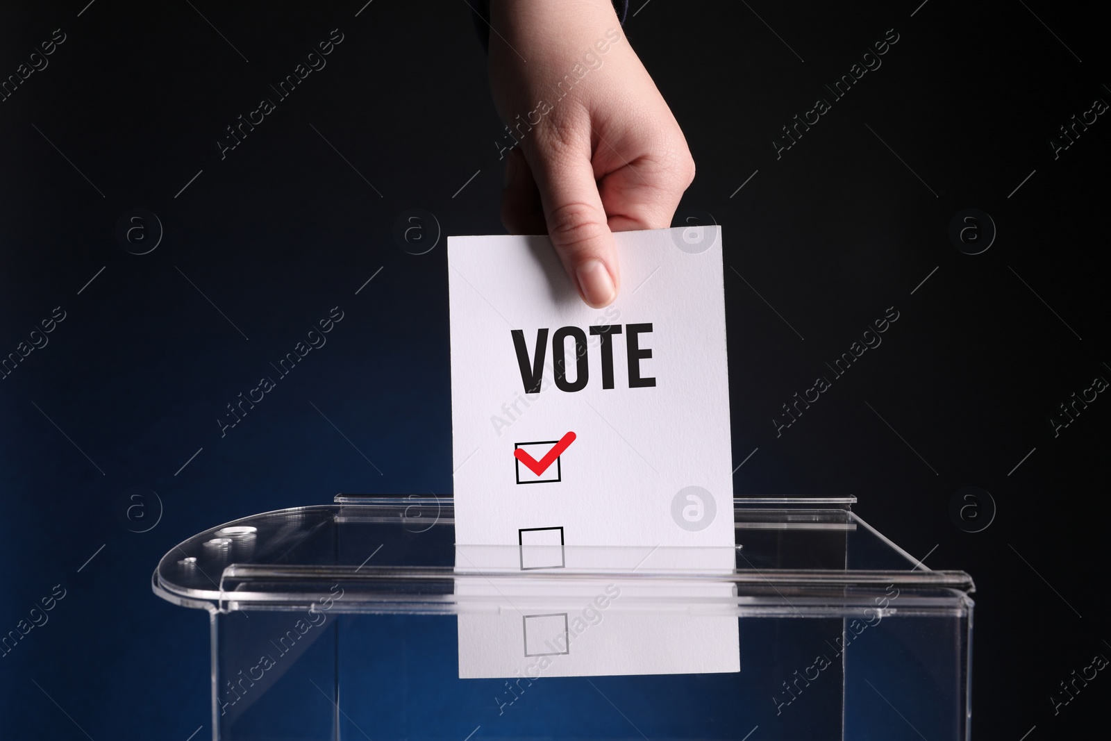 Image of Woman putting paper with word Vote and tick into ballot box on dark blue background