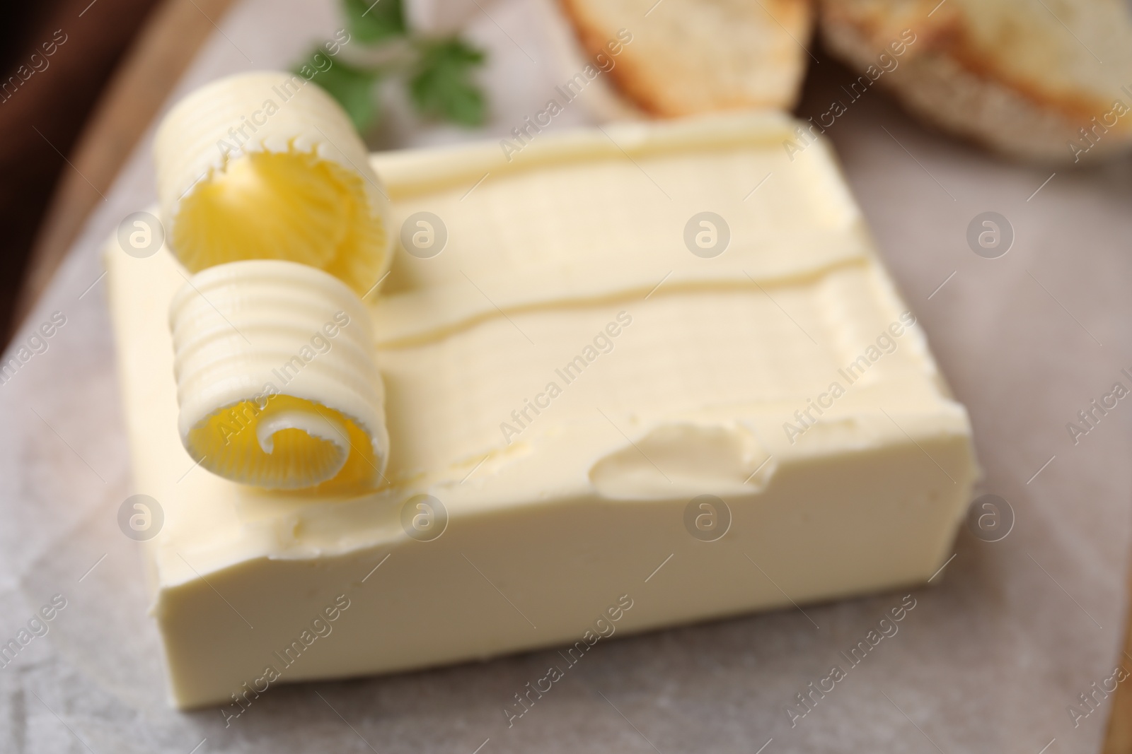 Photo of Tasty butter and curls on table, closeup