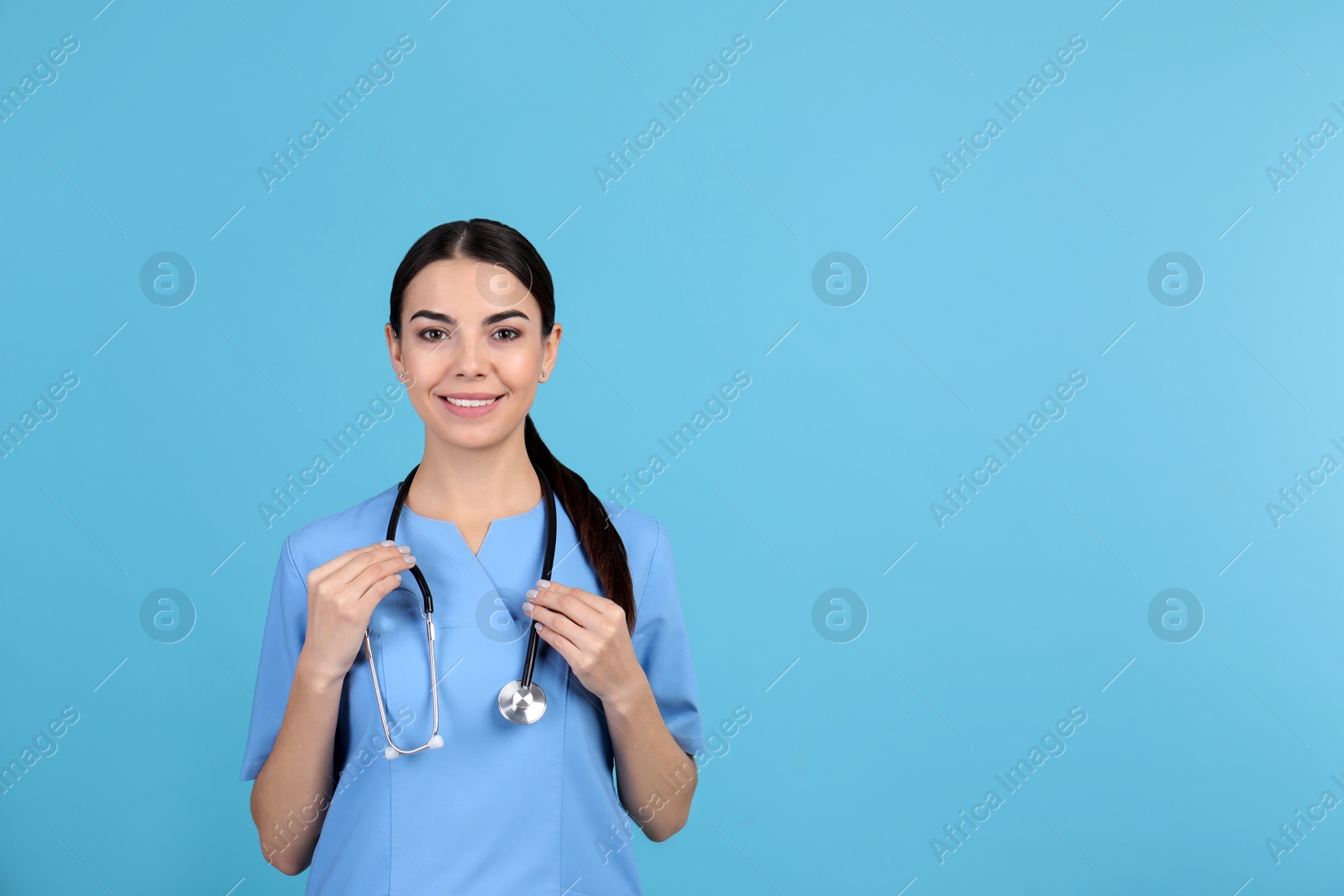 Photo of Portrait of medical assistant with stethoscope on color background. Space for text