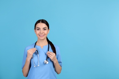 Photo of Portrait of medical assistant with stethoscope on color background. Space for text
