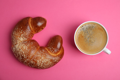 Delicious coffee and pastry on pink background, flat lay