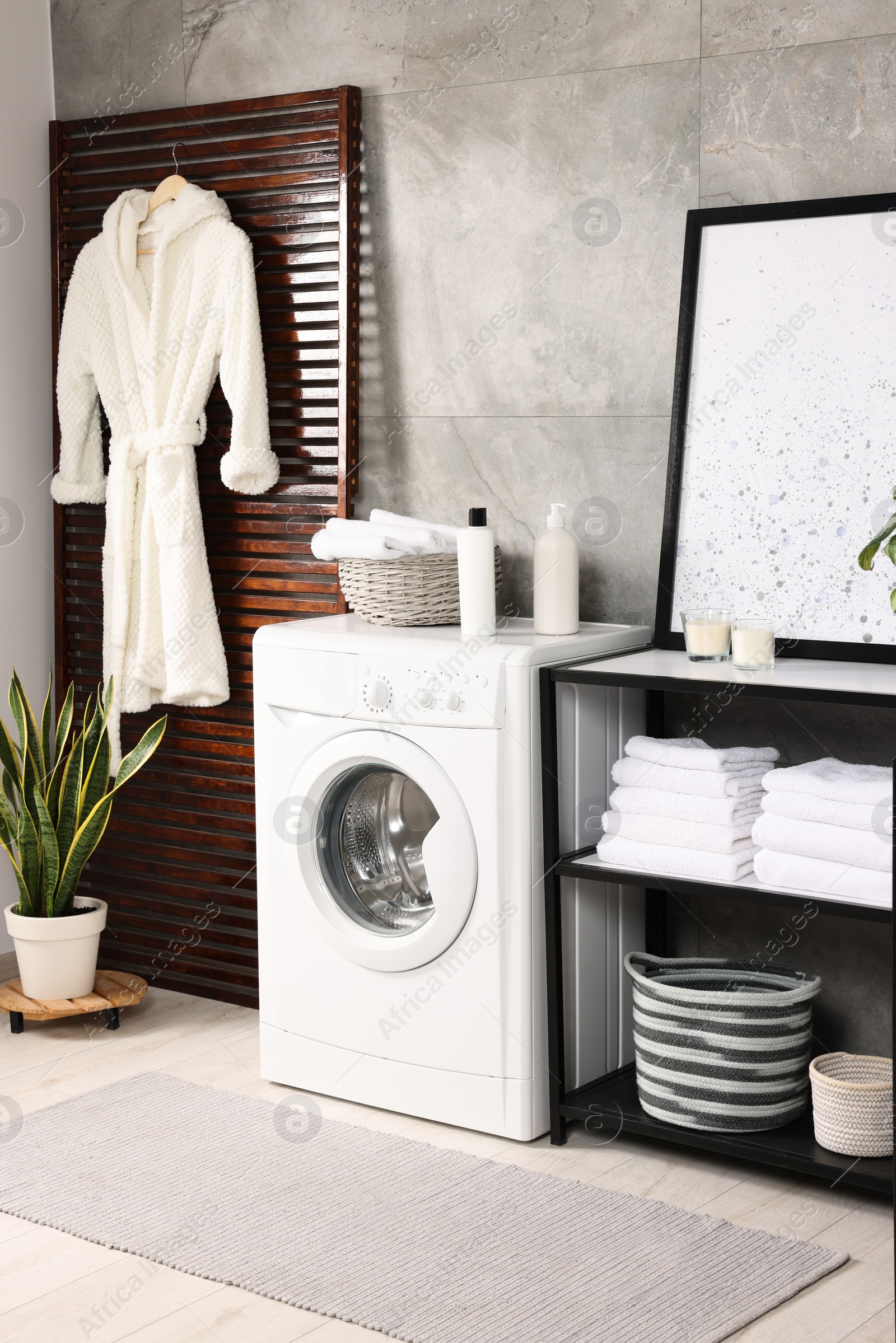 Photo of Stylish laundry room with modern washing machine. Interior design