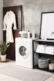 Stylish laundry room with modern washing machine. Interior design