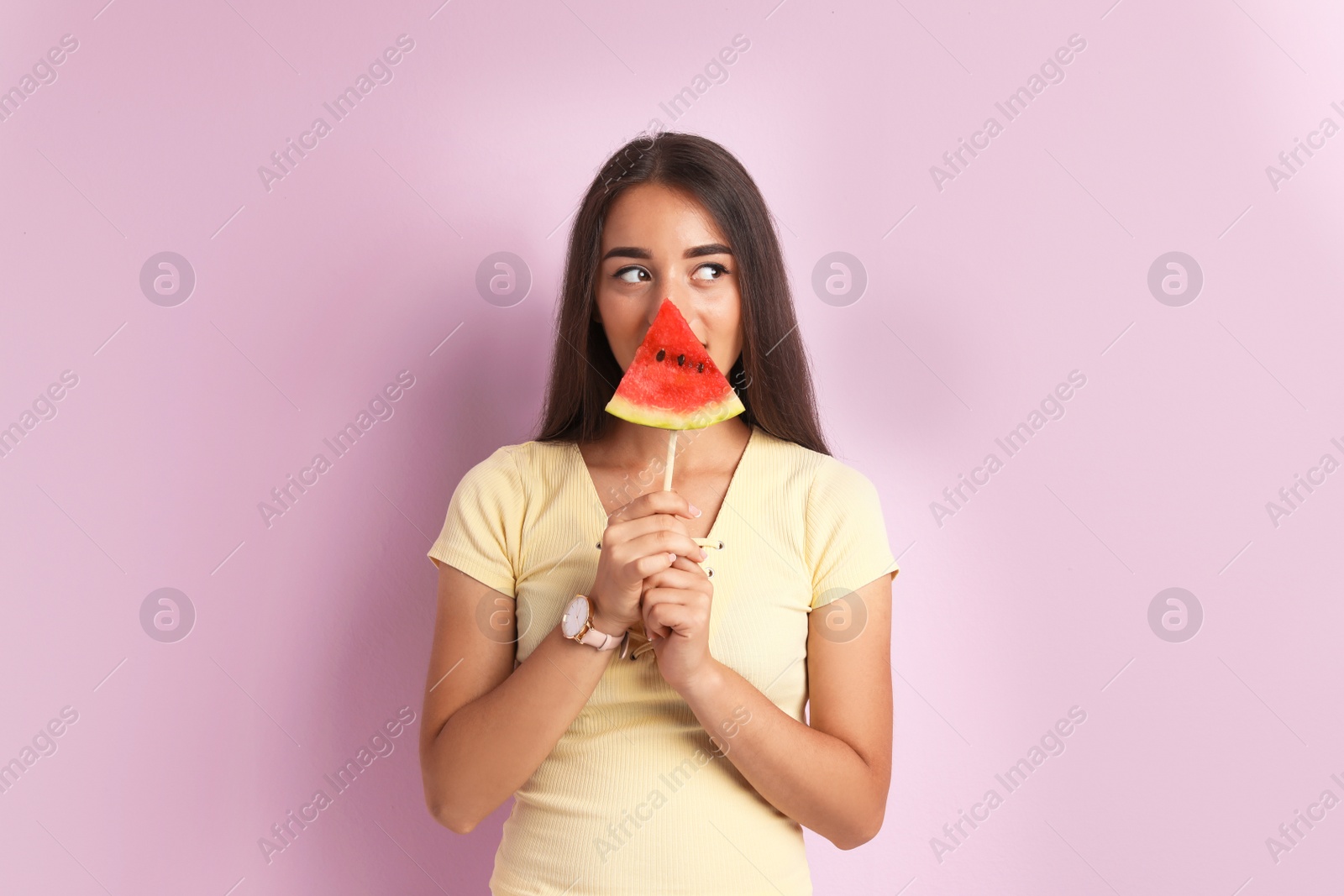 Photo of Beautiful young woman posing with watermelon on color background