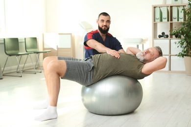 Photo of Physiotherapist working with patient in clinic. Rehabilitation therapy