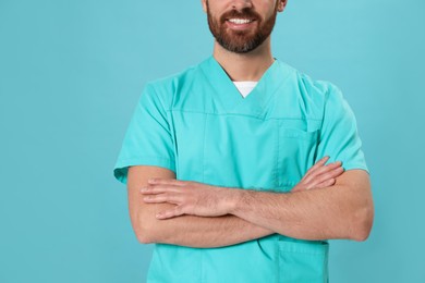 Nurse in medical uniform on light blue background, closeup