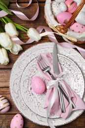 Photo of Festive table setting with painted eggs and tulips, flat lay. Easter celebration