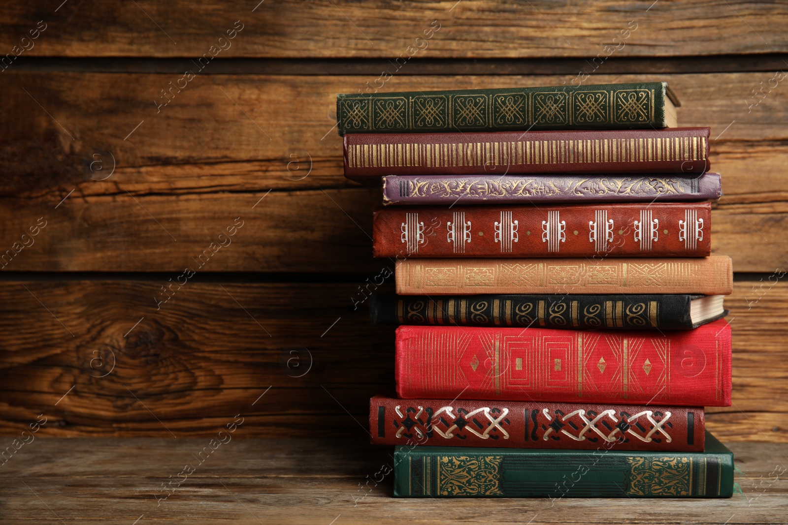 Photo of Collection of different books on table against wooden background. Space for text