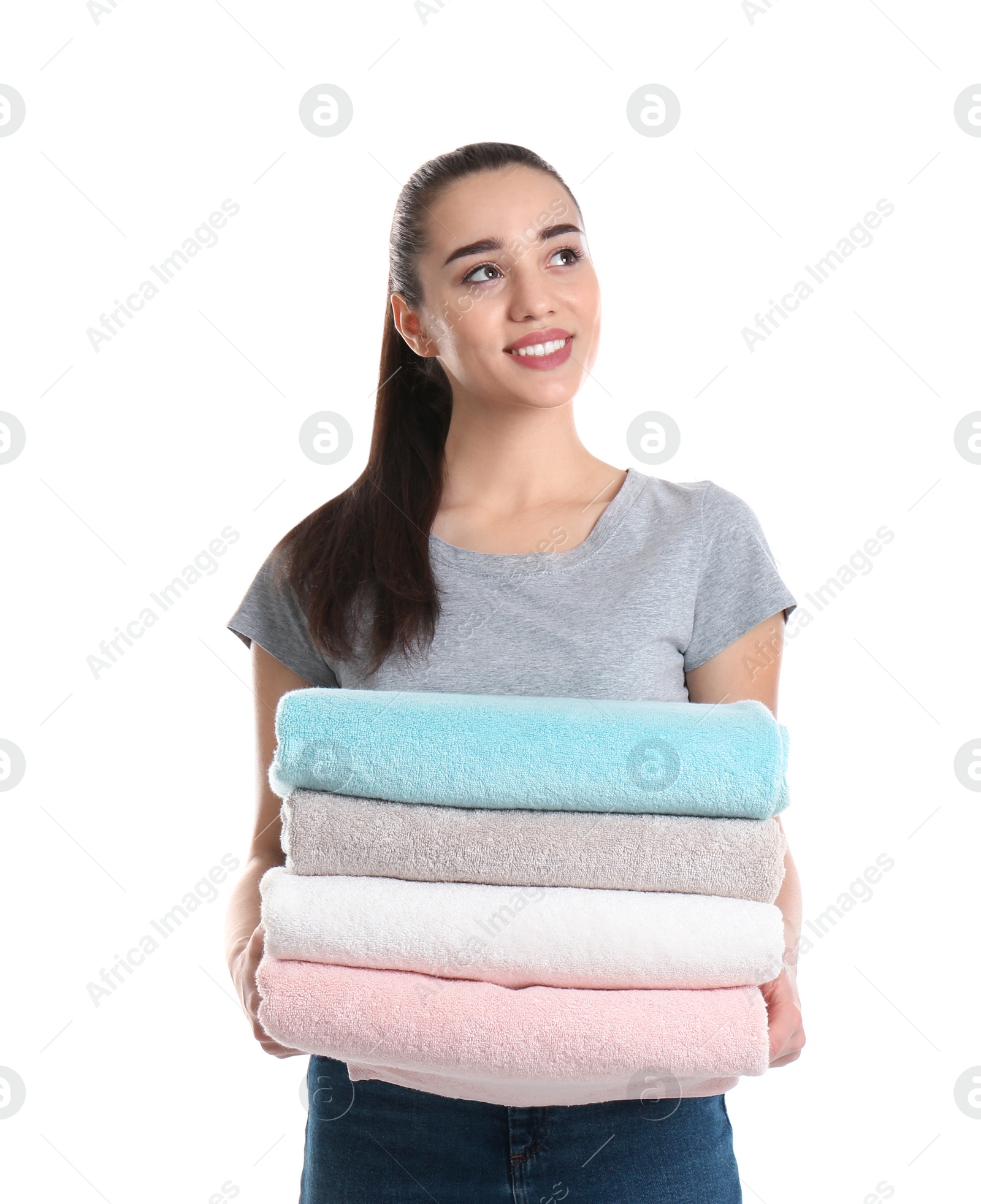 Photo of Happy young woman holding clean towels on white background. Laundry day