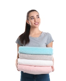 Happy young woman holding clean towels on white background. Laundry day