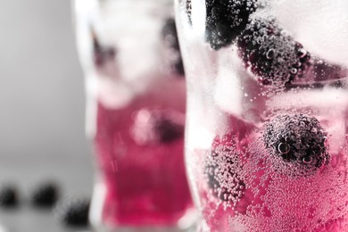 Refreshing blackberry drink with ice in glass, closeup. Space for text