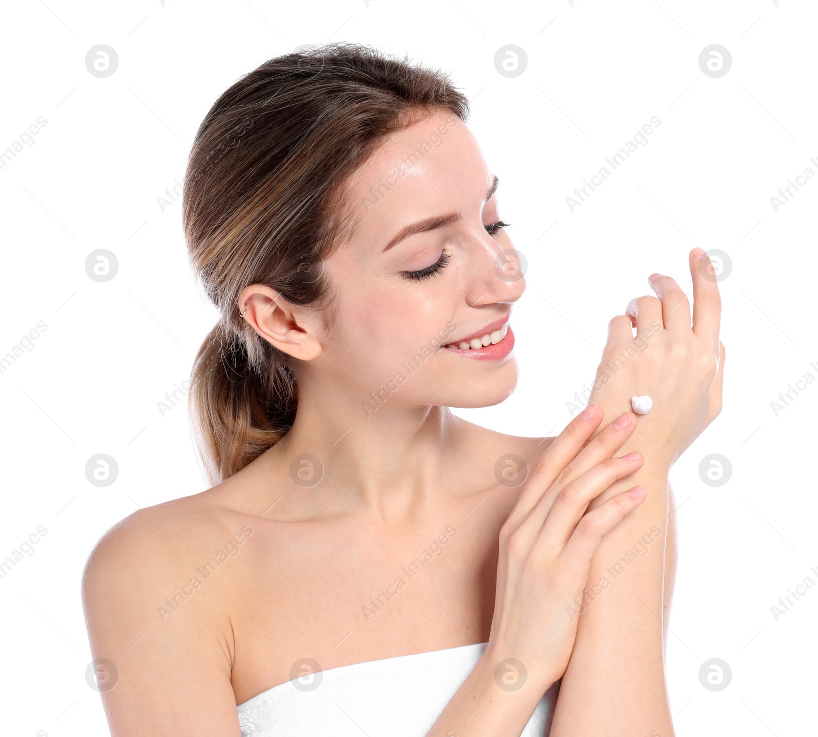 Photo of Young woman applying cream on her hand against white background. Beauty and body care