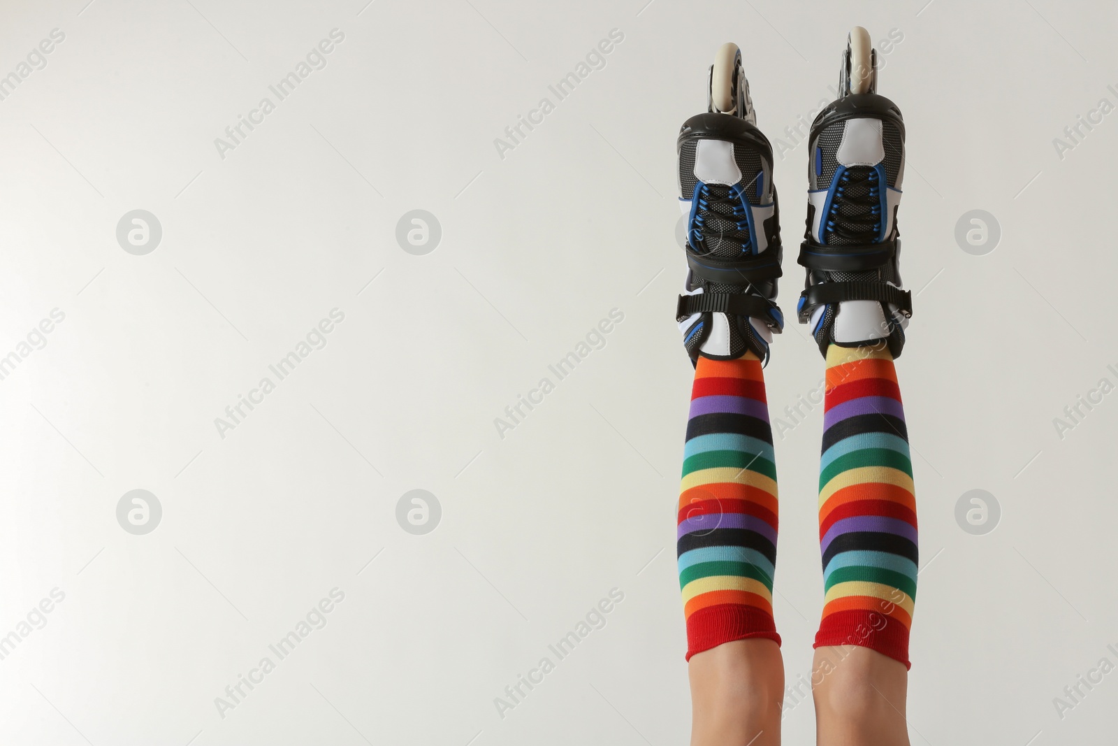 Photo of Woman with roller skates on white background, closeup. Space for text