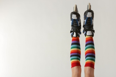 Woman with roller skates on white background, closeup. Space for text