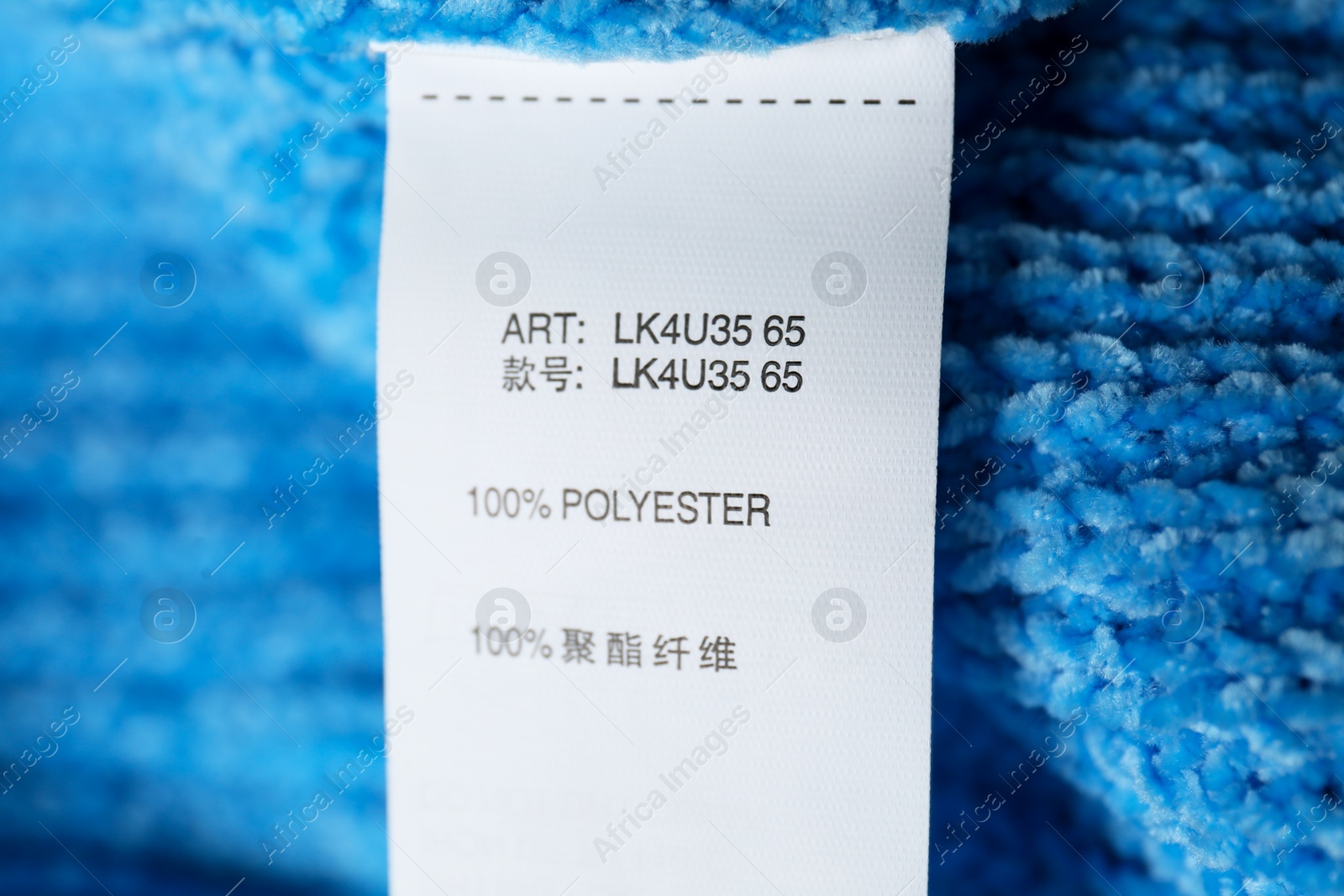 Photo of Clothing label with material content on blue sweater, closeup view