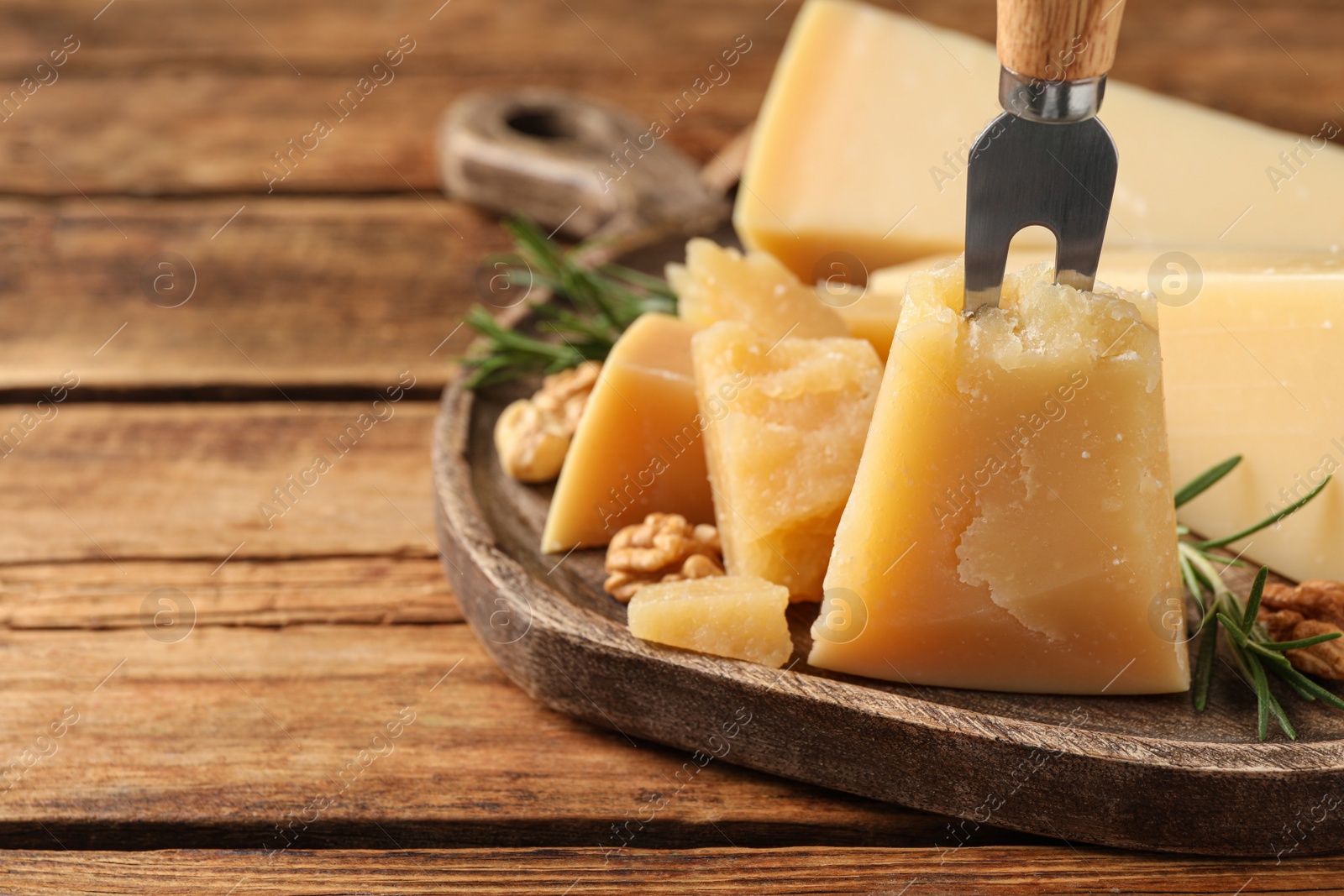 Photo of Delicious parmesan cheese on wooden table, closeup. Space for text