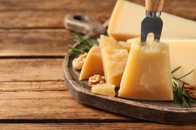 Photo of Delicious parmesan cheese on wooden table, closeup. Space for text