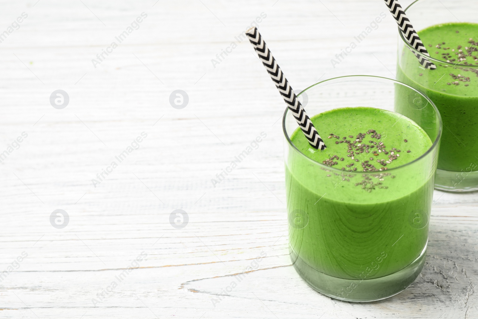 Photo of Tasty kale smoothie on white wooden table. Space for text