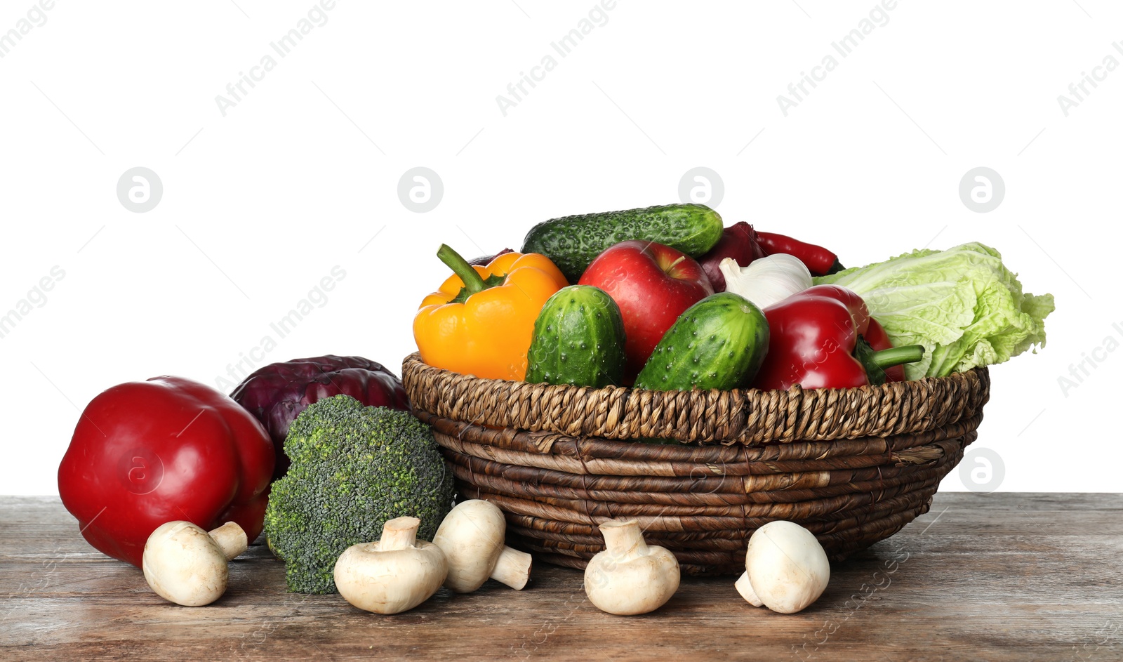 Photo of Wicker bowl with variety of fresh delicious vegetables and fruits on table against white background