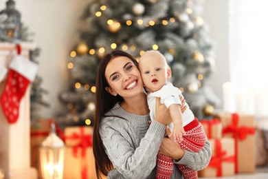 Photo of Mother with her cute baby at home. Christmas celebration