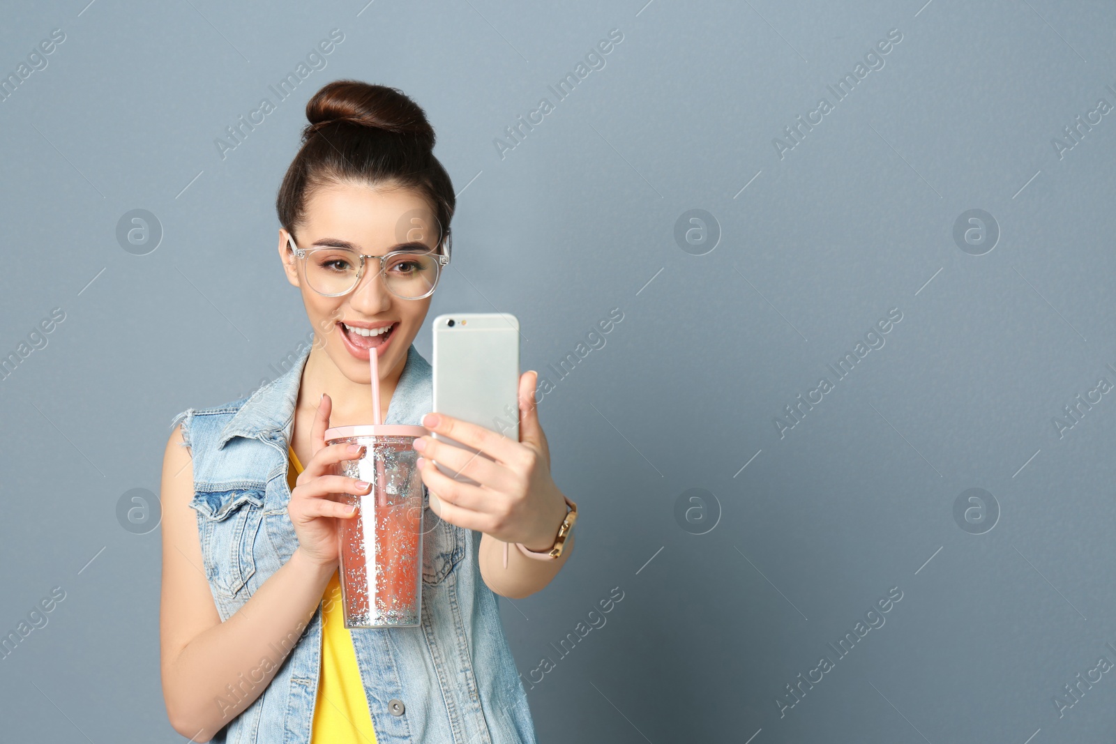 Photo of Young beautiful woman taking selfie against grey background