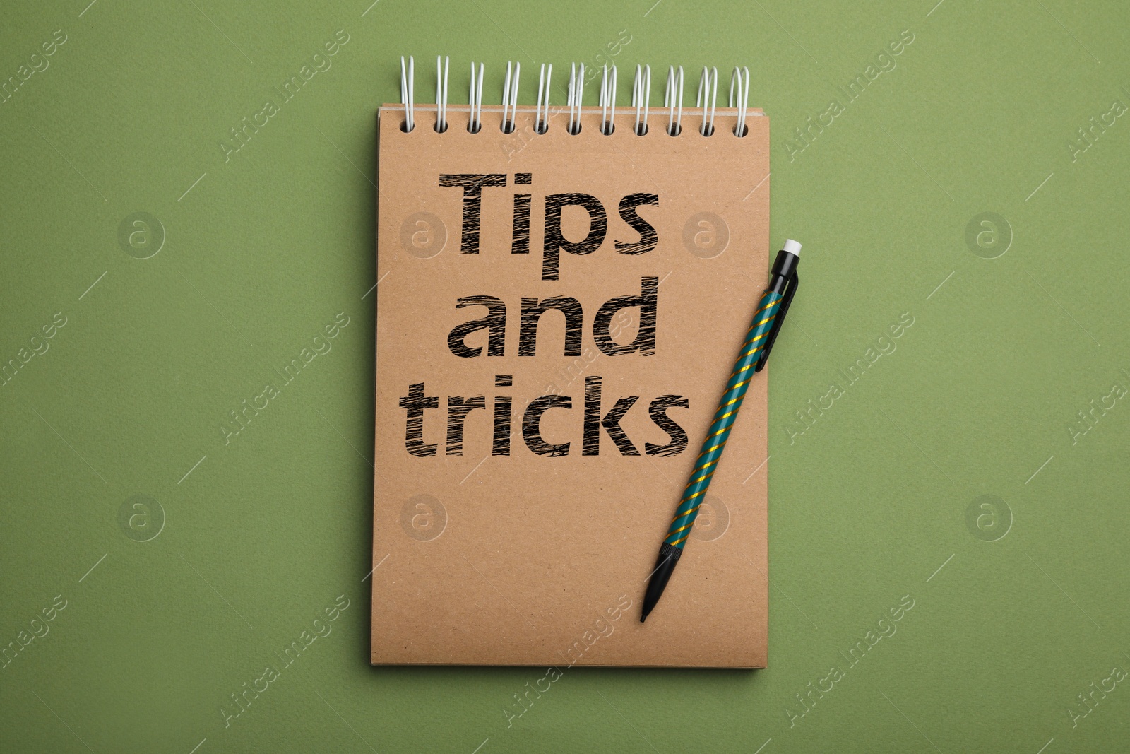 Image of Notebook with text Tips and tricks on green background, top view