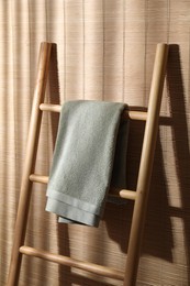 Green terry towel on wooden ladder indoors