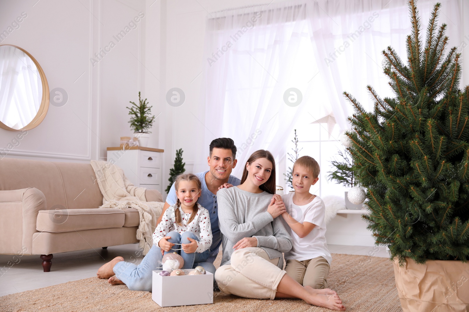 Photo of Happy family with cute children near Christmas tree together at home