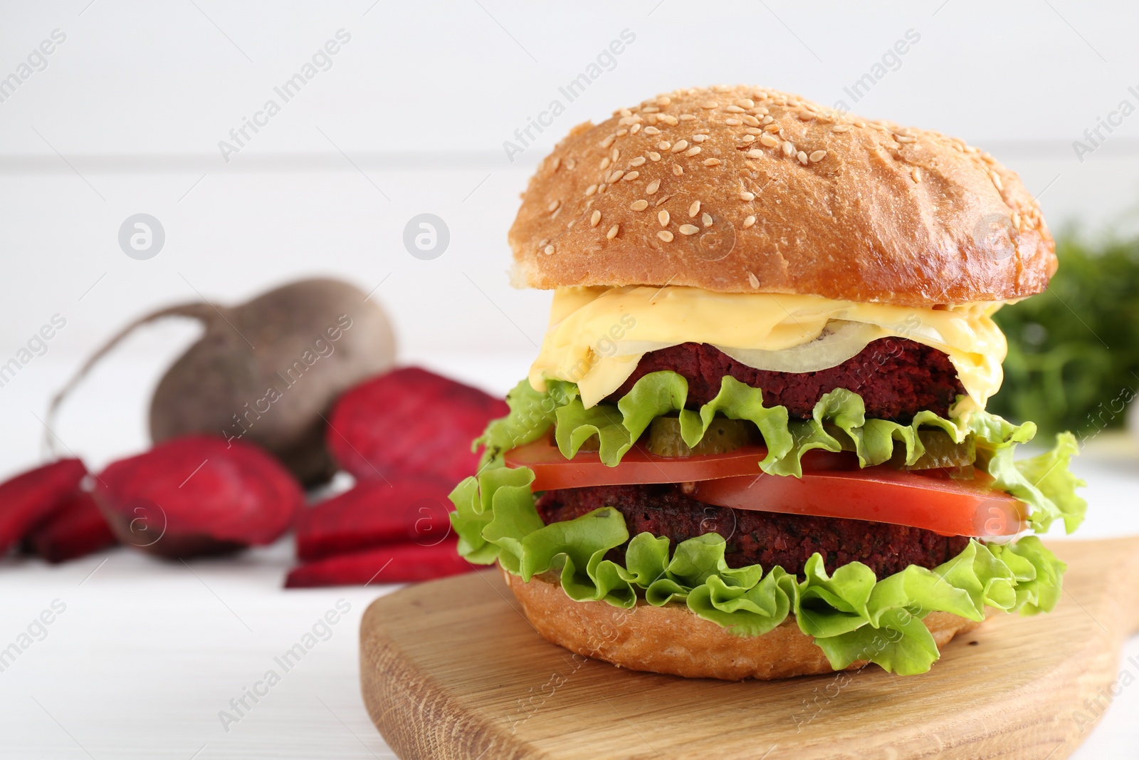 Photo of Delicious vegetarian burger on white table, space for text