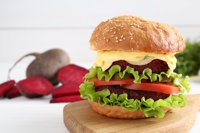 Photo of Delicious vegetarian burger on white table, space for text