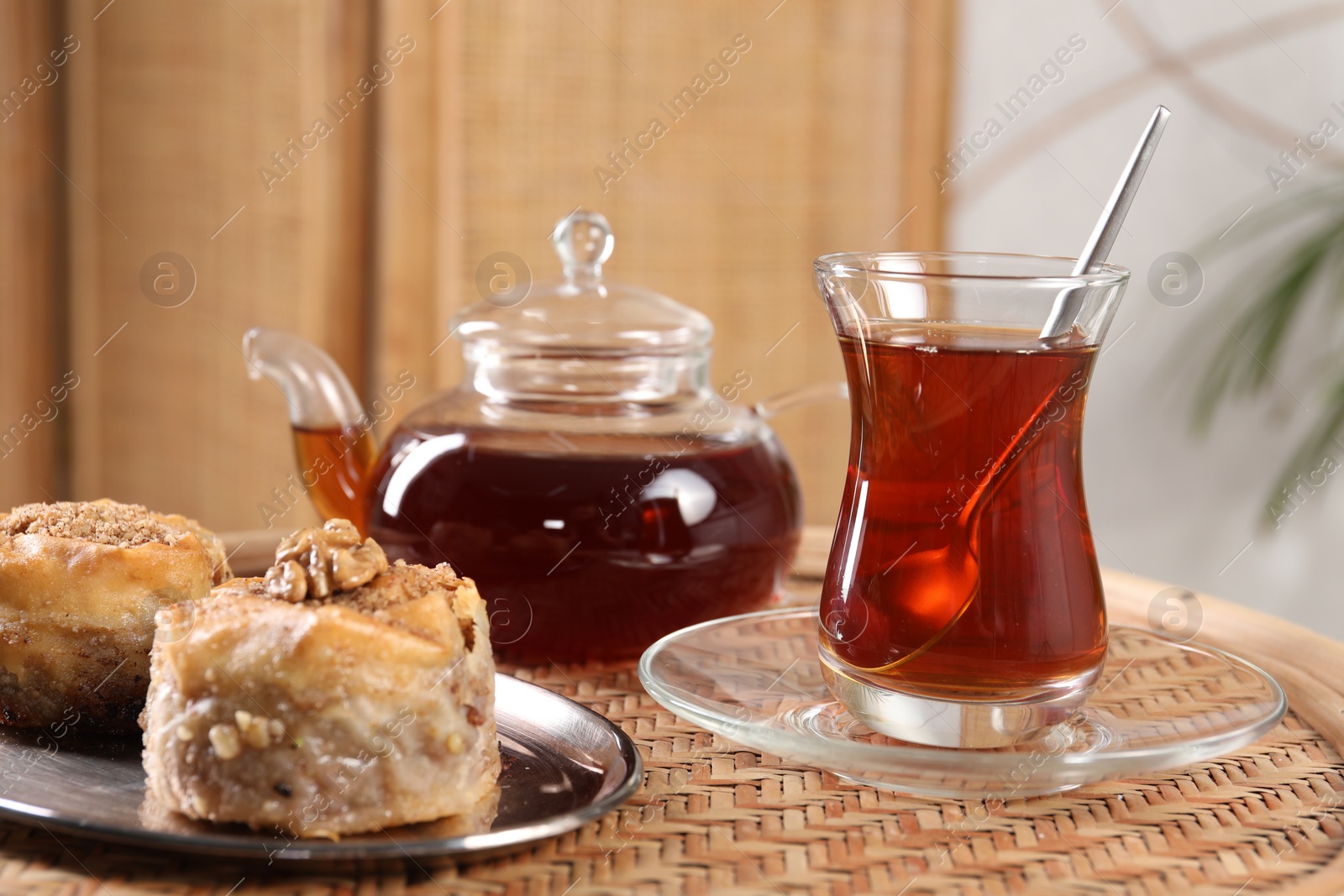 Photo of Traditional Turkish tea and fresh baklava on wicker table