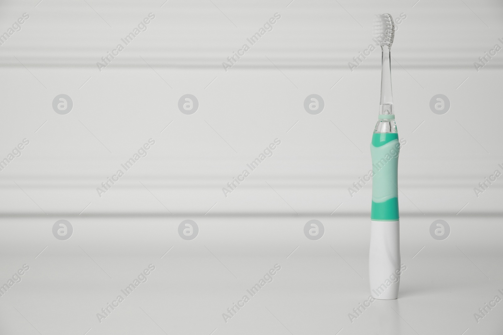 Photo of Electric toothbrush on white background, space for text