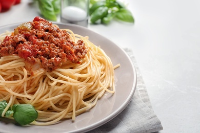 Photo of Plate with delicious pasta bolognese on table