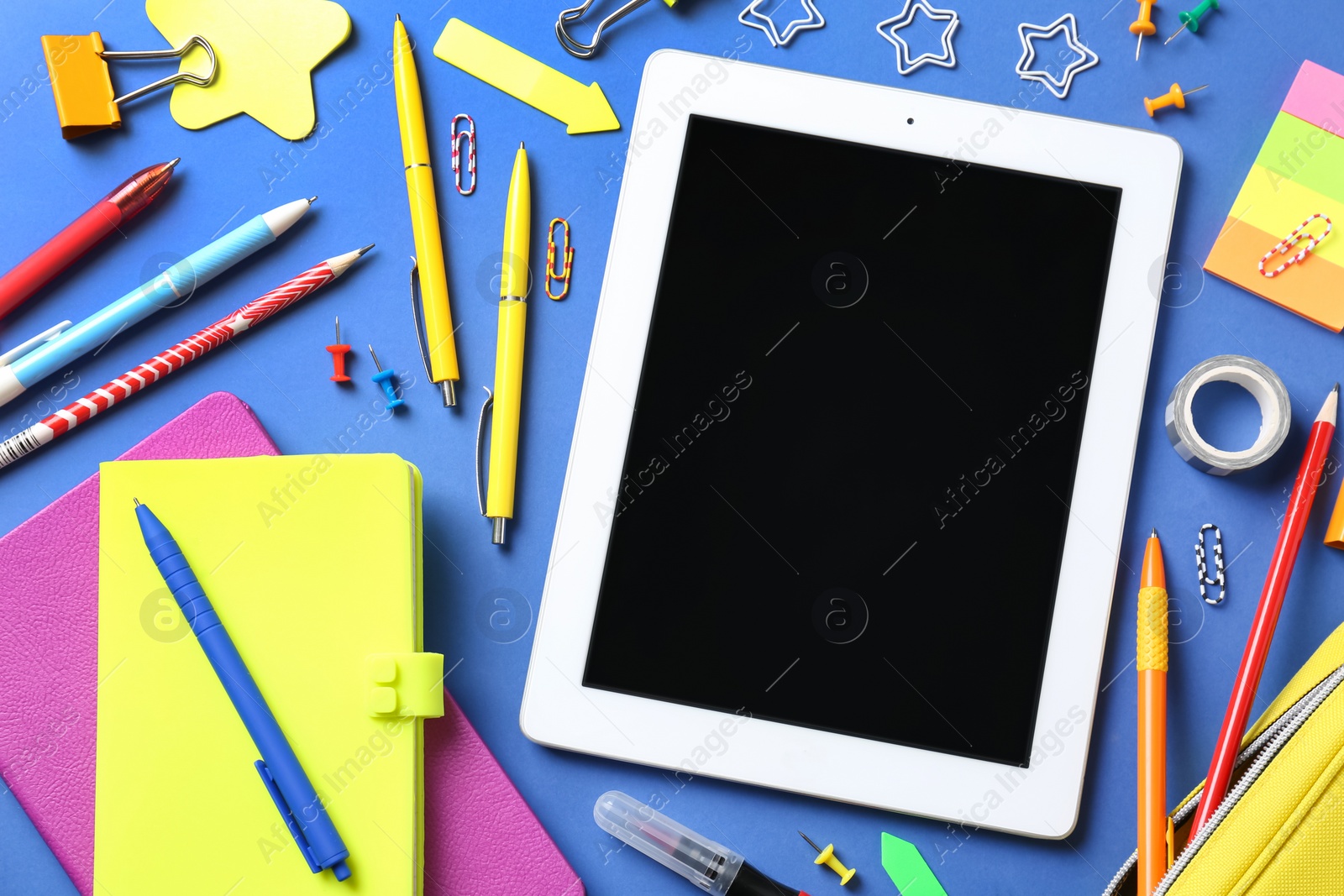 Photo of Flat lay composition with tablet on blue background