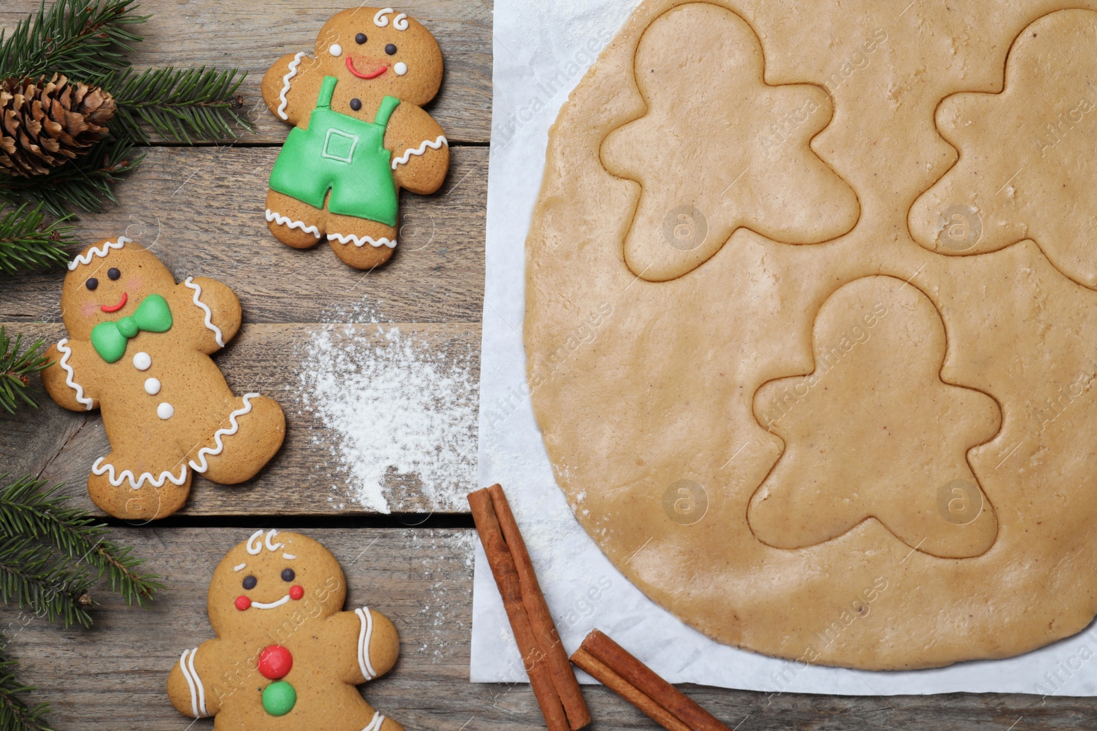 Photo of Flat lay composition with homemade gingerbread man cookies on wooden table