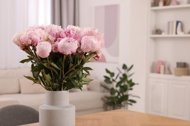 Photo of Vase with pink peonies on wooden table in dining room. Space for text