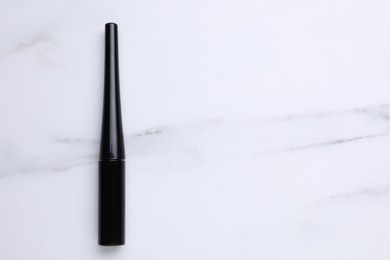 Photo of Black eyeliner on white marble table, top view with space for text. Makeup product