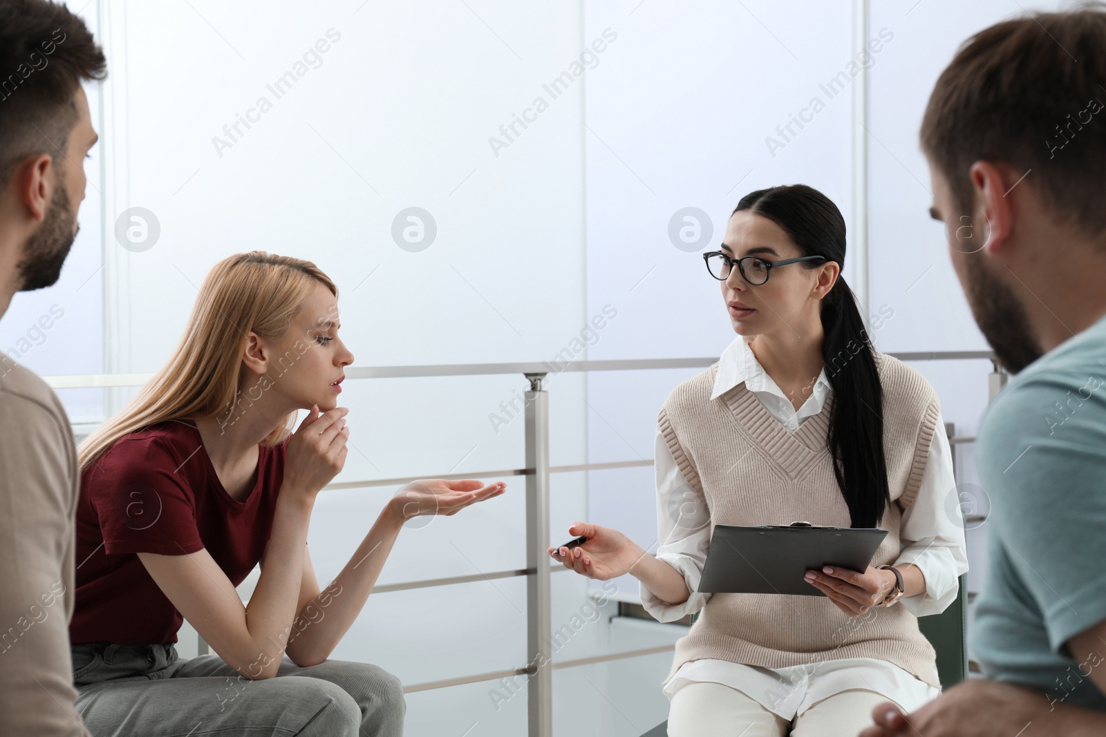Photo of Psychotherapist working with group of drug addicted people at therapy session indoors