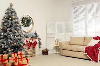 Photo of Stylish Christmas interior with decorated fir tree and fireplace