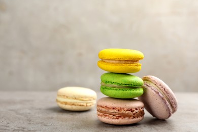 Photo of Delicious macarons on grey table. Space for text