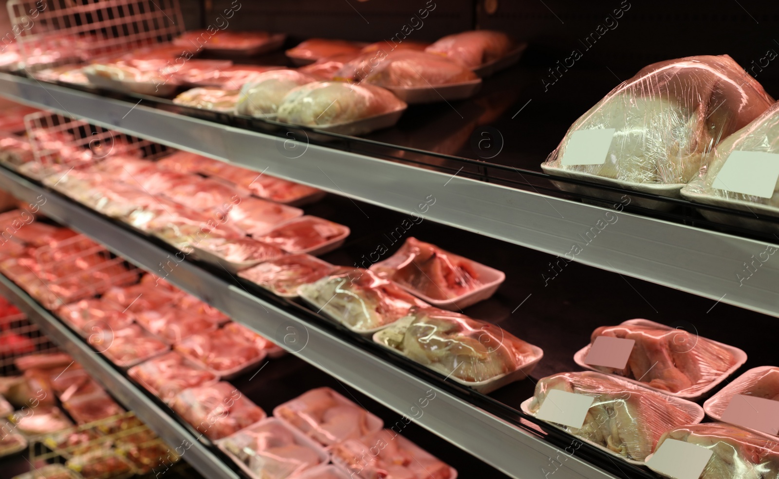 Photo of Shelves with packed chicken meat in supermarket