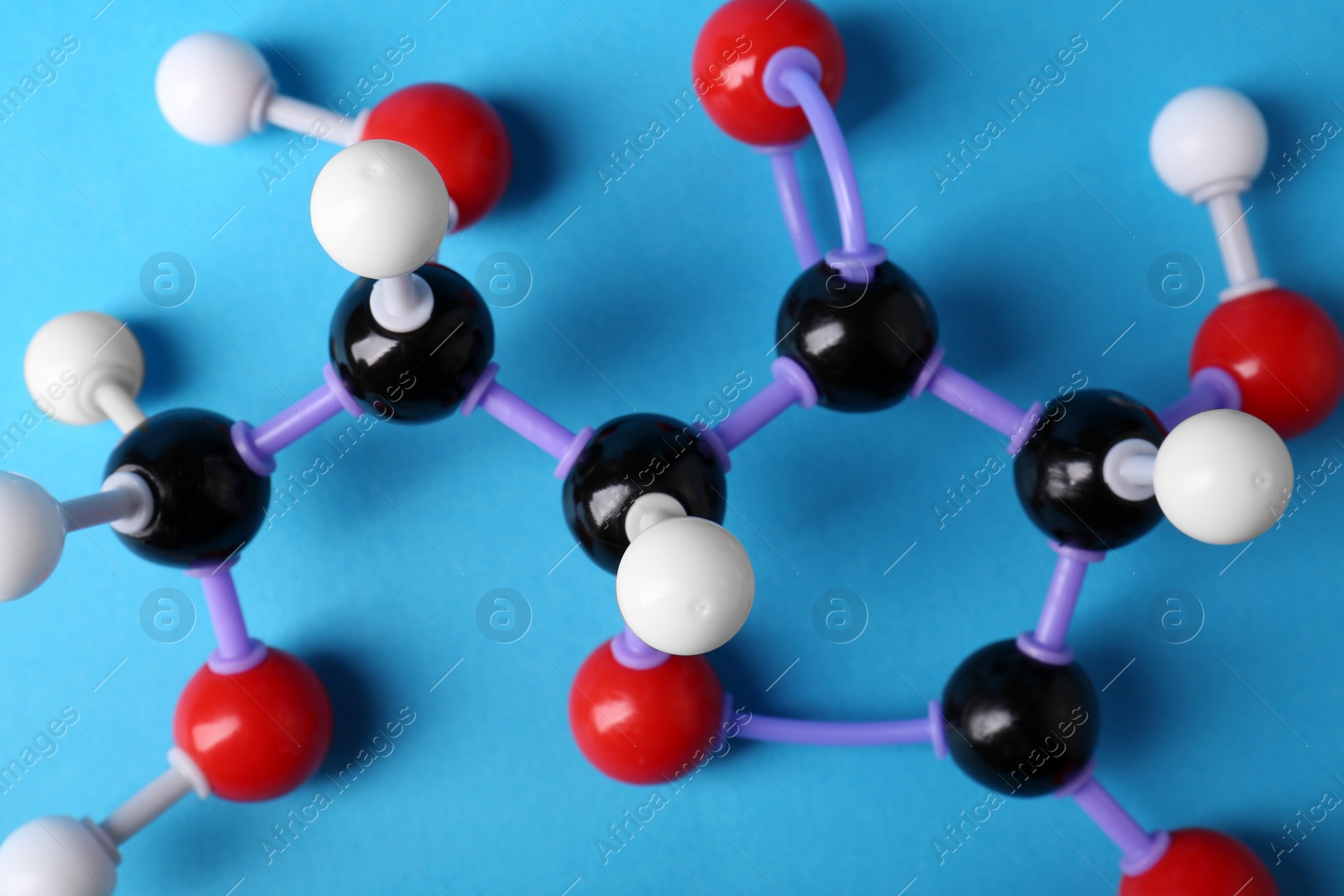 Photo of Molecule of vitamin C on light blue background, top view. Chemical model