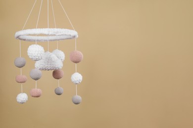 Photo of Cute baby crib mobile on beige background. Space for text
