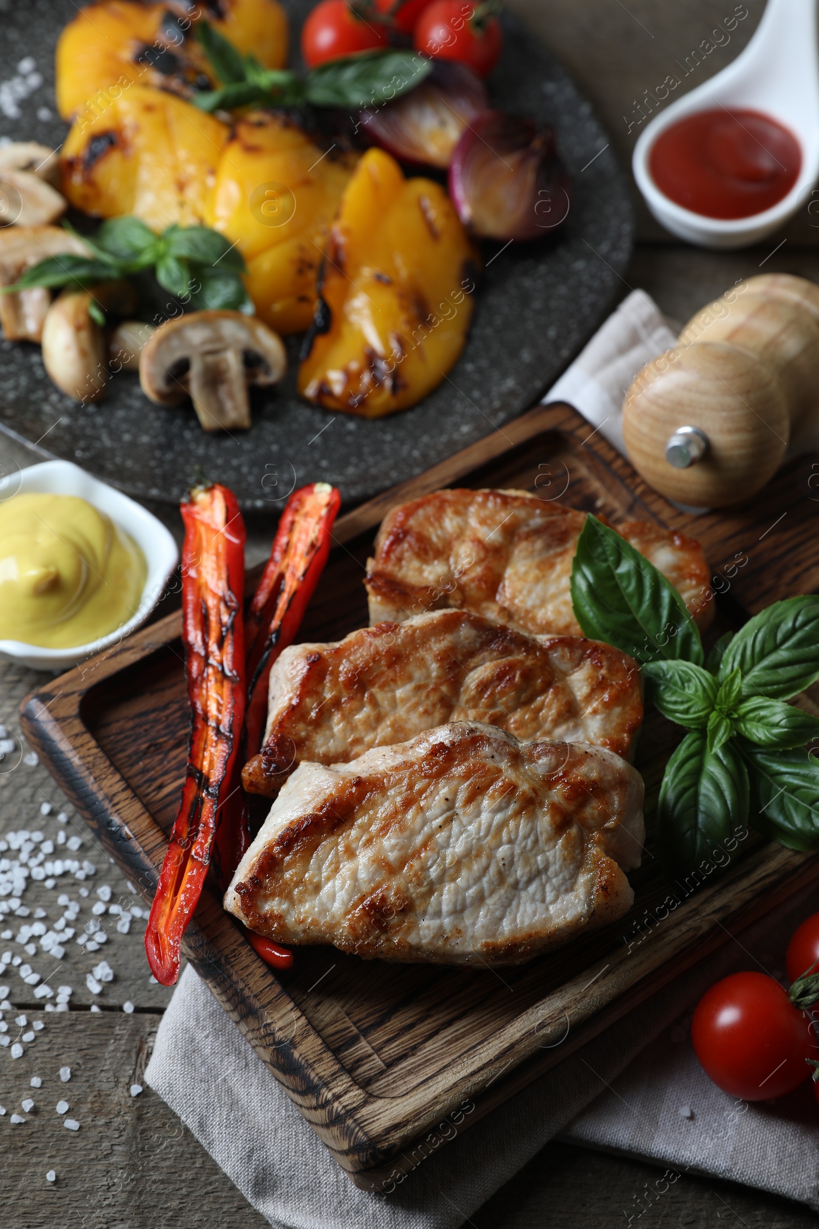 Photo of Delicious grilled meat and vegetables served on wooden table