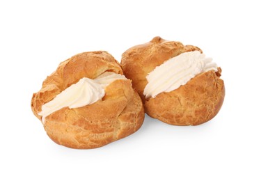 Delicious profiteroles with cream filling on white background