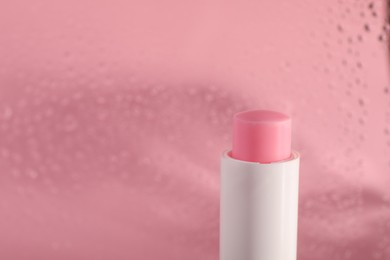 Photo of One lip balm on pink background, closeup. Space for text