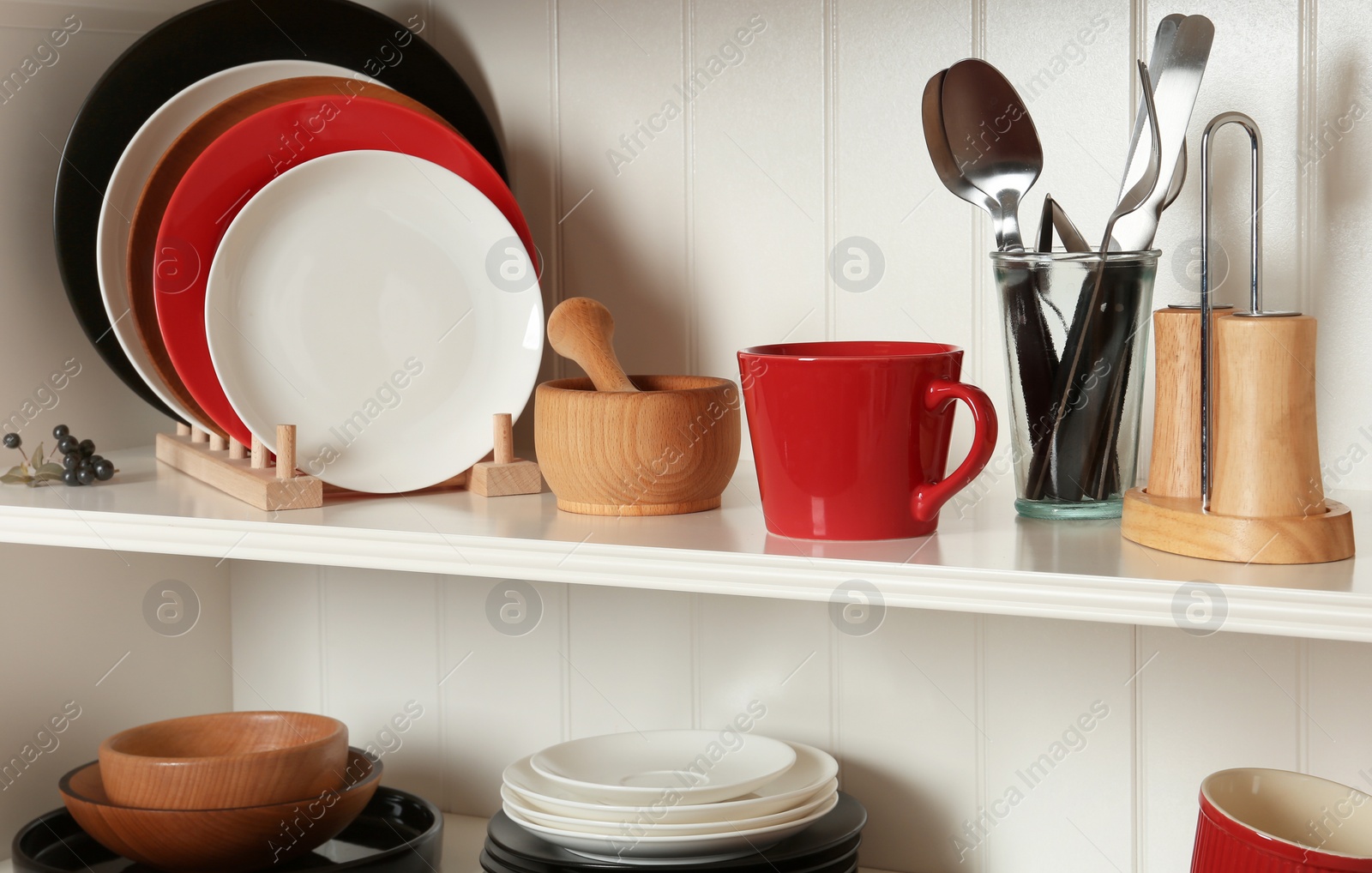 Photo of White shelving unit with set of dishware